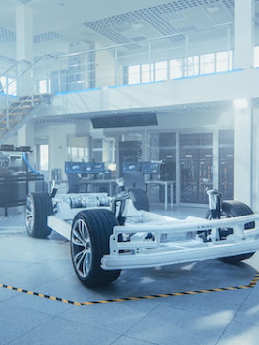Concept of Authentic Electric Car Platform Chassis Prototype Standing in High Tech Industrial Machinery Design Laboratory. Hybrid Frame include Tires, Suspension, Engine and Battery.